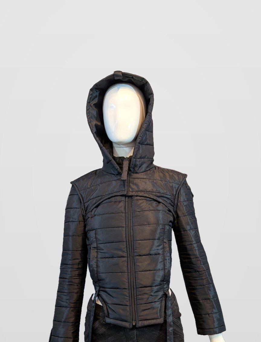 Black Nova Puffer — black futuristic hooded quilted puffer jacket on a mannequin, framed just below the jacket hem